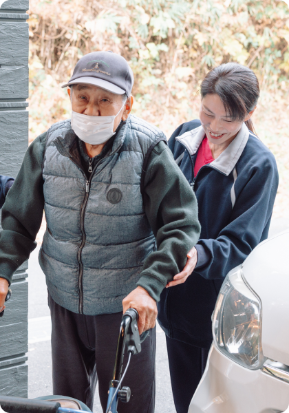 高齢者をサポートしながら歩くスタッフ