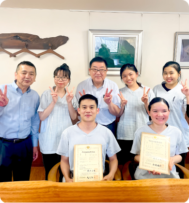 資格を取得し、資格証を持ったスタッフ達