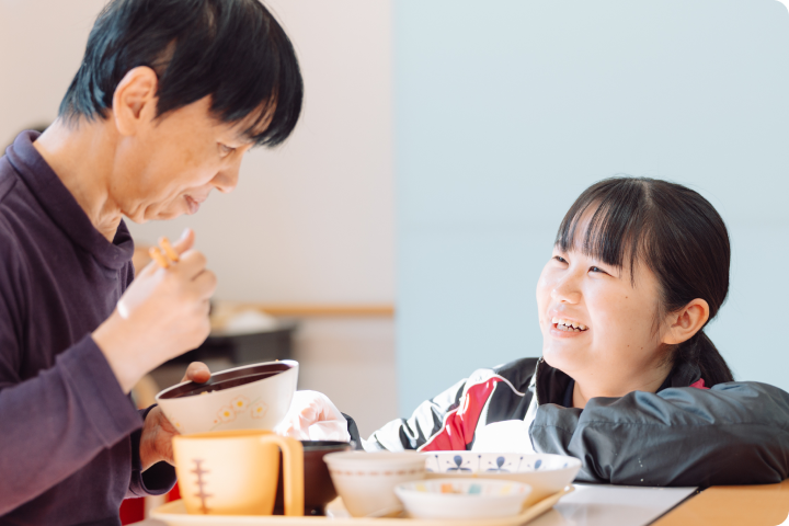 食事する女性とスタッフ