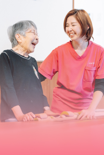 楽しそうに会話する女性スタッフと高齢者